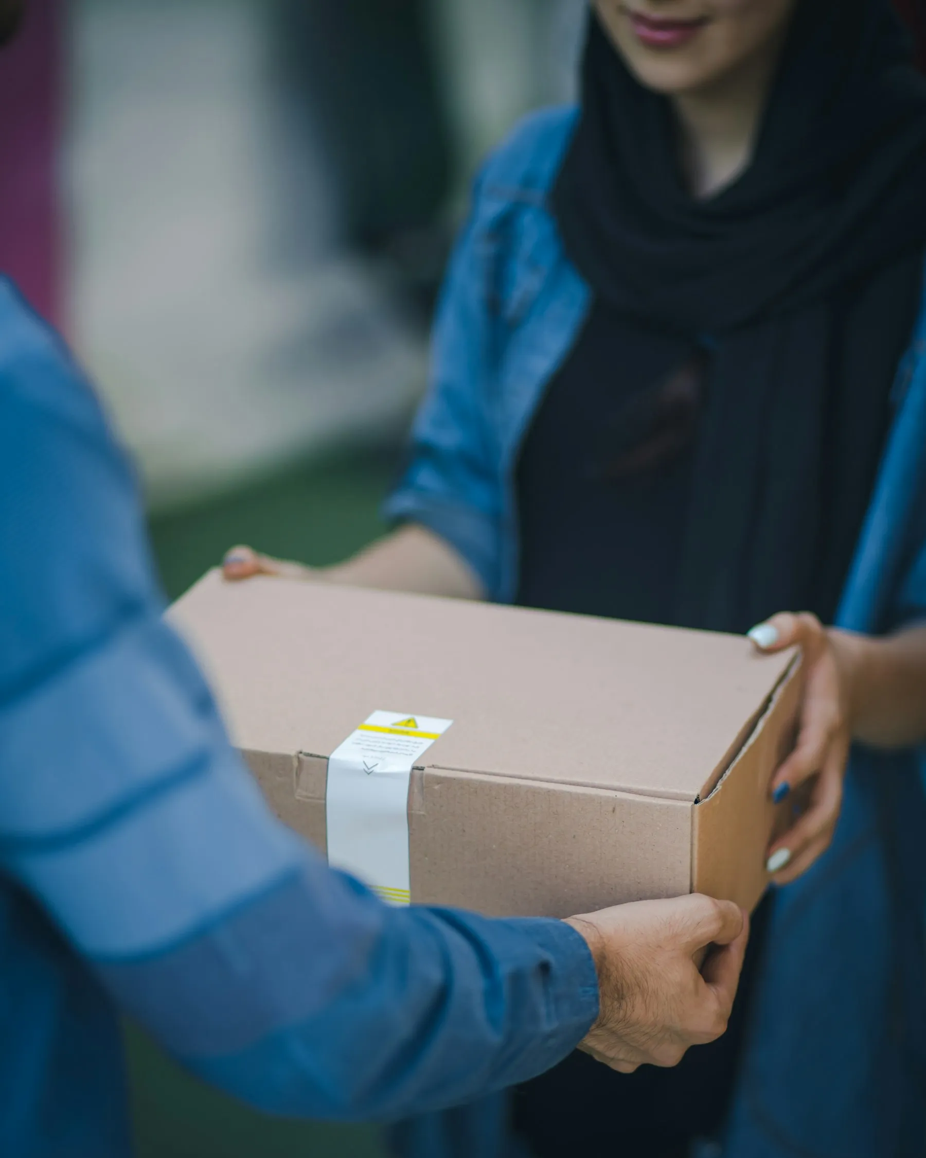 Person handing over a packed cardboard box