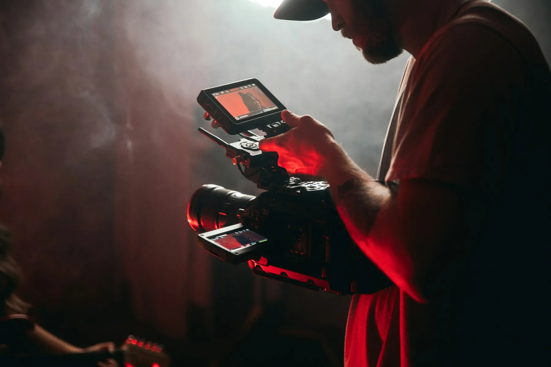 Videographer adjusting a camera during a content shoot